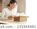 A Japanese woman looks happy after opening her package 135844881