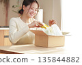 A Japanese woman looks happy after opening her package 135844882