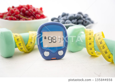 Glucometer and vegetables on desk 135844938