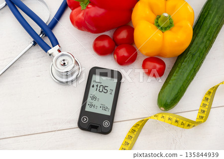 Glucometer and vegetables on desk Glucometer and vegetables on desk 135844939