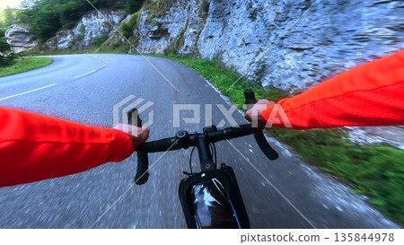 POV road cycling through rocky mountain gorge on winding alpine road POV road cycling through rocky mountain gorge on winding alpine road 135844978