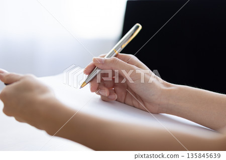 特寫鏡頭：一位女士的手拿著活頁夾做筆記 135845639