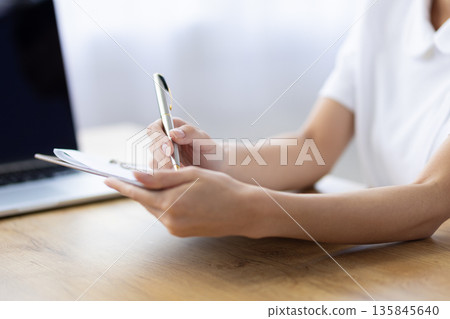 特寫鏡頭：一位女士的手拿著活頁夾做筆記 135845640