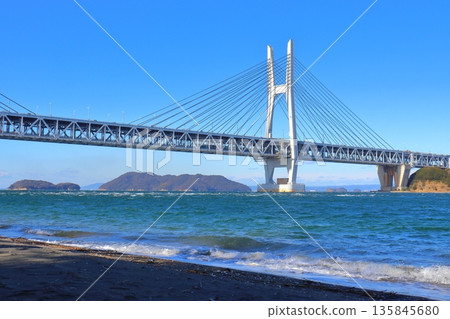 從岩黑島黑濱海灘望去，可以看到一列火車正從瀨戶內大橋（瀨戶內大橋線）下方穿過。 135845680