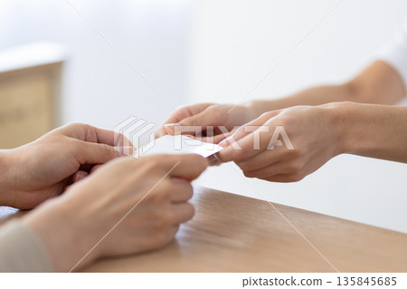 一位身穿白大褂的女士在接待處收到一張賀卡。 135845685