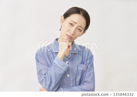 Woman in pajamas, troubled, white background Woman in pajamas, troubled, white background 135846332