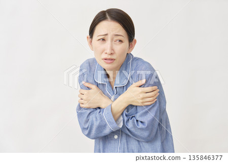 Woman in pajamas, cold, white background 135846377
