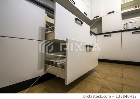 Open kitchen drawer with plates inside, a smart solution for kitchen storage and organizing 135846412