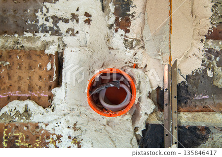 Socket orange boxes with wires in a wall. Cabling installation of electrical wires sticking out from electrical sockets hole on brick wall. Socket orange boxes with wires in a wall. Cabling installation of electrical wires sticking out from electrical sockets hole on brick wall. 135846417