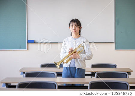 一位微笑的小學生拿著小號 135846780