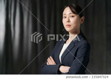 一位身穿西裝、雙臂交叉的女士 135847324
