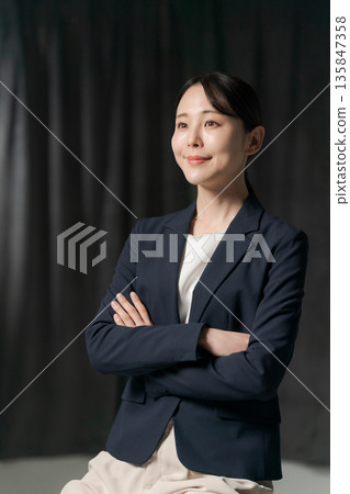 雙臂交叉穿西裝的女人 雙臂交叉穿西裝的女人 135847358