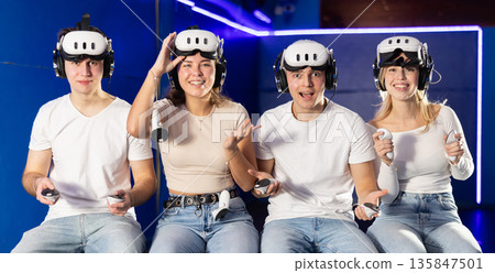 Friends playing video games in virtual reality headsets Friends playing video games in virtual reality headsets 135847501