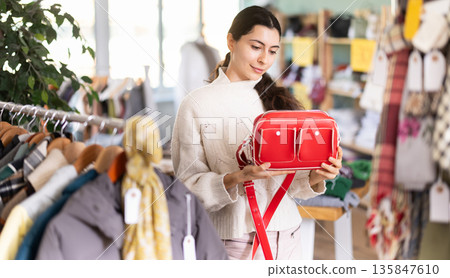 Regular customer Armenian woman chooses color and style of handbag 135847610