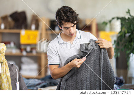 In chain shop, young man choose sweater In chain shop, young man choose sweater 135847754