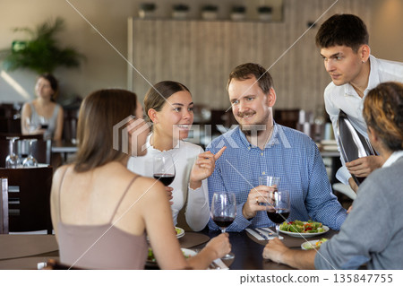 Waiter takes order from couple of men and women Waiter takes order from couple of men and women 135847755