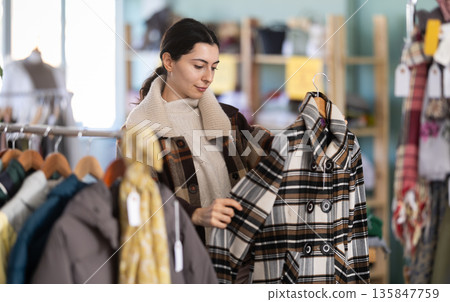 Armenian woman choosing outerwear in the store 135847759