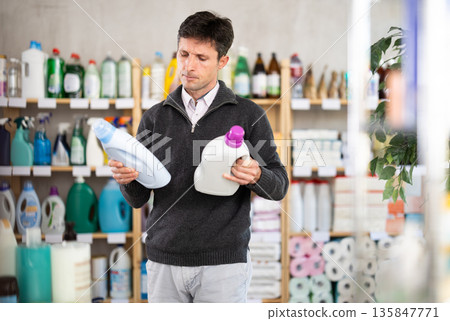 Man consumer with household chemical products for washing indoors Man consumer with household chemical products for washing indoors 135847771