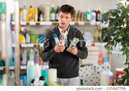man buys toothbrushes in a store 135847796