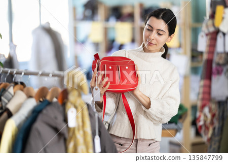 Regular customer Armenian woman chooses color and style of handbag 135847799