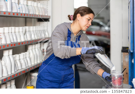 Girl auto colorist combines different paint colors 135847823
