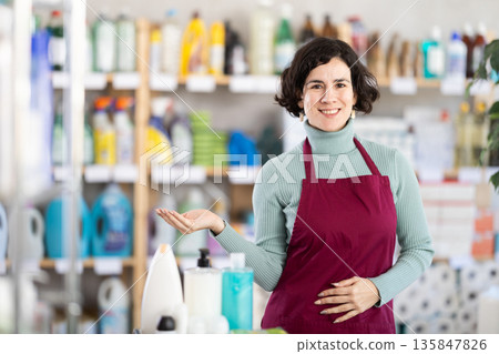Middle-aged saleswoman welcoming clients in retail store Middle-aged saleswoman welcoming clients in retail store 135847826