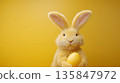 Fluffy yellow rabbit with easter egg on yellow background 135847972
