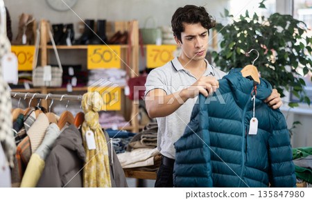 In chain shop, guy choose down jacket In chain shop, guy choose down jacket 135847980