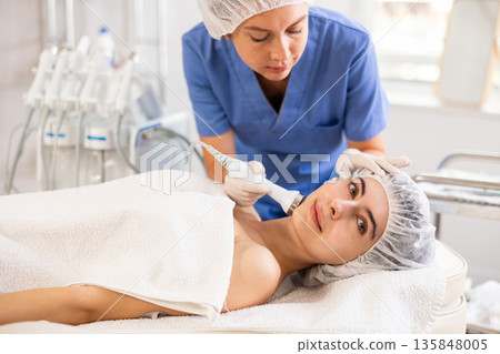 Female client undergoing anti-aging ultrasonic phonophoresis procedure on face Female client undergoing anti-aging ultrasonic phonophoresis procedure on face 135848005