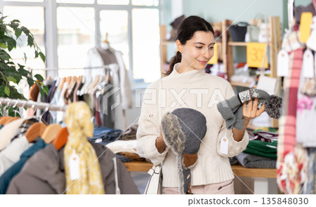 Regular customer Armenian woman chooses color and style of knitted hat 135848030