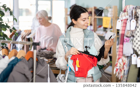 Female shopper selects panties in fashionable clothing boutique 135848042