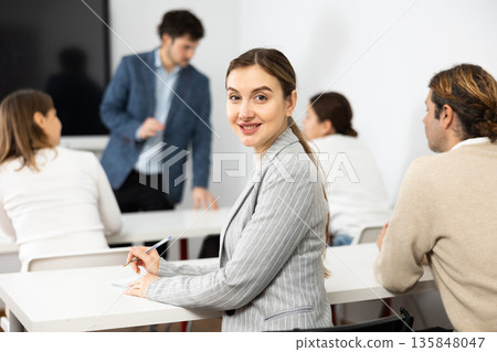 Young smiling female student attending class in university diligently 135848047