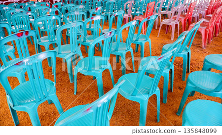 Rows of Teal and Red Plastic Chairs for Social Gathering Rows of Teal and Red Plastic Chairs for Social Gathering 135848099