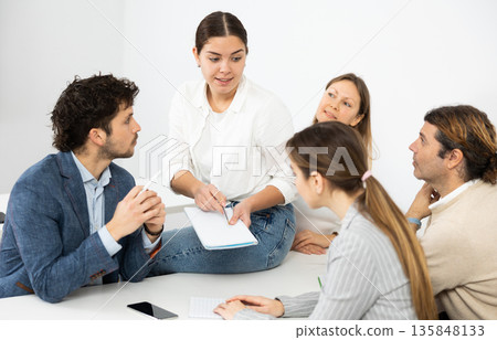 Emotional language teacher telling interesting stories to adult attentive students during class break in auditory 135848133