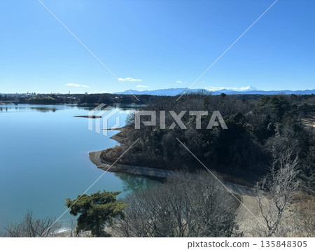 A beautiful panoramic view of the calm surface of Lake Tama under a clear blue sky and Mount Fuji floating on the horizon A beautiful panoramic view of the calm surface of Lake Tama under a clear blue sky and Mount Fuji floating on the horizon 135848305