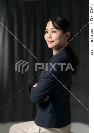 一位二十多歲的女子,穿著西裝(黑色背景) 一位二十多歲的女子,穿著西裝(黑色背景) 135848546