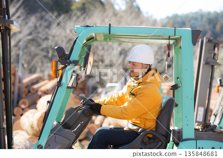 Worker carrying lumber with a forklift Worker carrying lumber with a forklift 135848681
