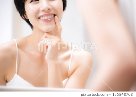 Checking your beautiful teeth in the mirror - Imagining orthodontics and whitening Checking your beautiful teeth in the mirror - Imagining orthodontics and whitening 135848768