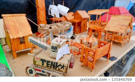 Miniature Handcrafted Village with Cardboard Tank and Popsicle Stick Houses, Creative Recycled Art Project, Unique DIY Scale Models 135848769