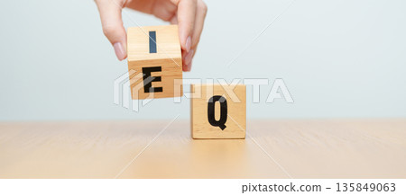 hand change wooden block from IQ to EQ, balance between intelligence quotient and emotional quotient, AQ Adversity, MQ, Moral, SQ and Social quotient concepts 135849063