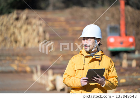 A man in work clothes wearing a helmet and looking up 135849548
