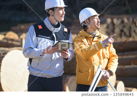 A man measuring a log with a vernier caliper and a tablet 135849645