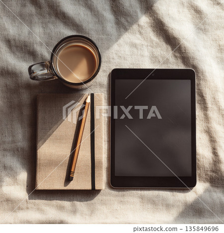 Overhead view of a minimalist work desk with a tablet, notebook and coffee 135849696