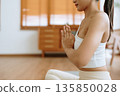 Young Asian woman meditating in lotus position at home 135850028