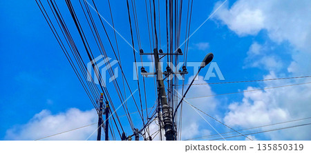 Messy Overhead Power Lines and Telecommunication Cables on Concrete Utility Pole 135850319