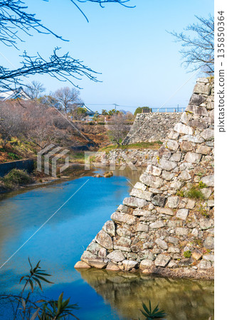 A view of Yamatokoriyama Castle's stone walls, where the Kun-yagura tower once stood, and the stone walls supporting the castle tower base towering in the background. A view of Yamatokoriyama Castle's stone walls, where the Kun-yagura tower once stood, and the stone walls supporting the castle tower base towering in the background. 135850364