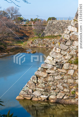 A view of Yamatokoriyama Castle's stone walls, where the Kun-yagura tower once stood, and the stone walls supporting the castle tower base towering in the background. 135850365