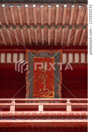 A plaque hanging on the temple gate and details of traditional vermilion architecture A plaque hanging on the temple gate and details of traditional vermilion architecture 135850532
