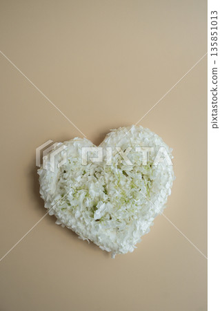 Symbol of love beautiful flower petals in heart shape in beige background. Creative concept of St Valentines day, weeding romantic date or anniversary. Copy space 135851013