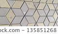 Close up, overhead view of interlocking paving stones forming a 3D cube illusion pattern with alternating gray and beige diamond rhombus shapes. 135851268